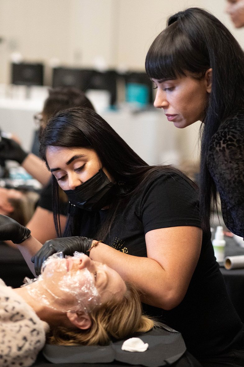 Students watching a treatment up close during a Privé live training