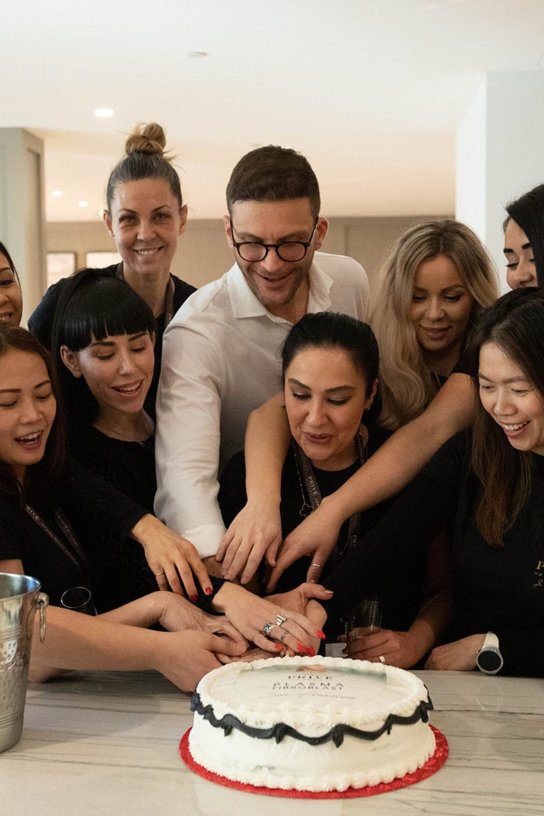 A Privé live-training group celebrating together around a cake