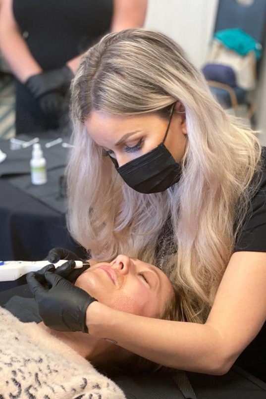 Specijalistica u zaštitnim rukavicama izvodi plasma tretman na licu klijentice